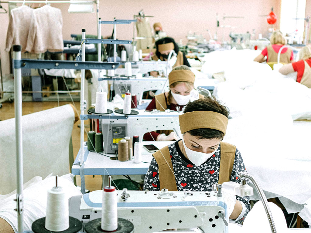 Näherinnen arbeiten unter fairen Arbeitsbedingungen an einer Nähmaschine.