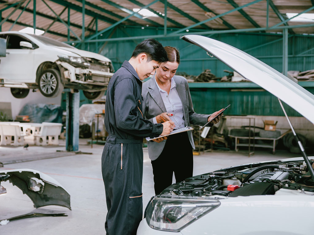 Eine Auditorin prüft die Arbeitsabläufe in der Automotive Branche.