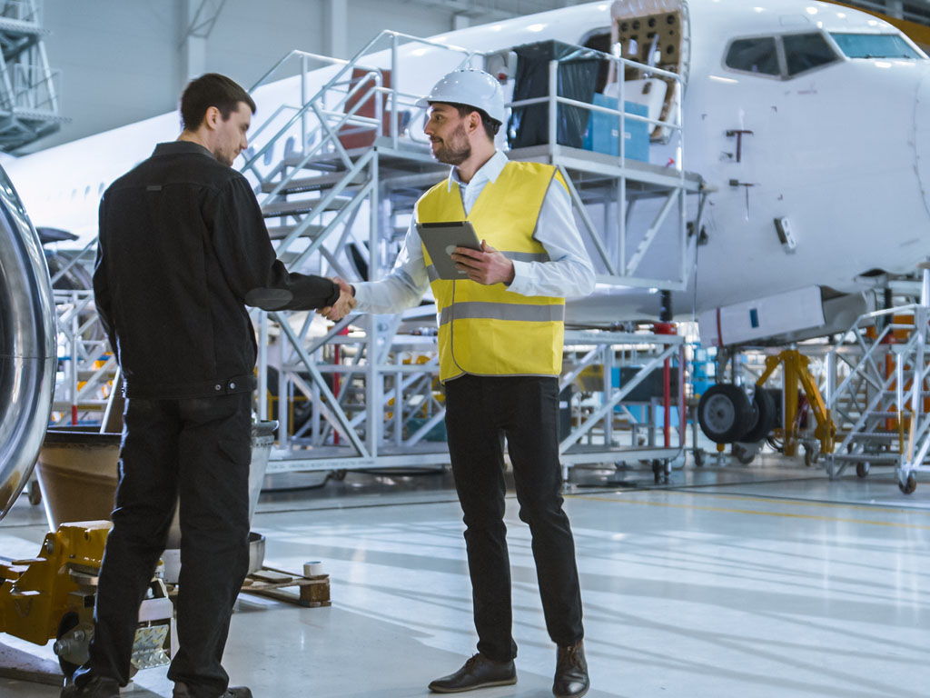 Ein Auditor spricht mit einem Ingenieur im Bereich Luftfahrt.