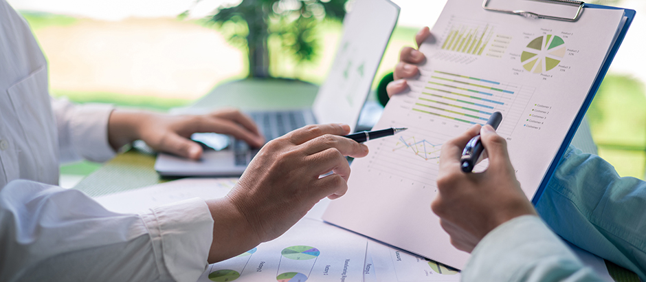 Überprüfung von Nachhaltigkeitsberichten und Umweltleistungsdiagrammen in einer Geschäftsbesprechung.