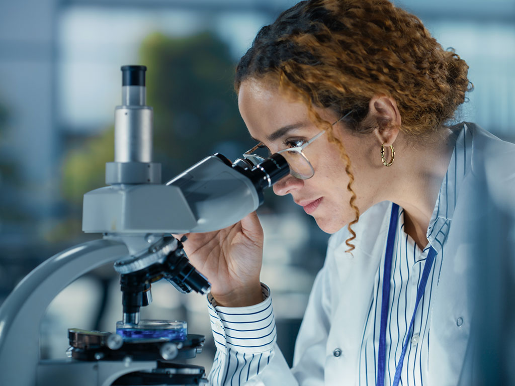 Labormanagerin im Bereich Medizin und Diagnostik arbeitet am Mikroskop